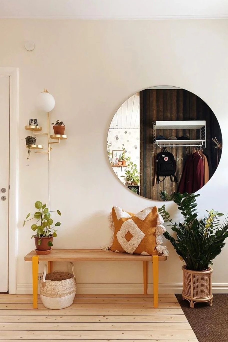 Sisusta eteinen boho-tyylillä penkillä, kuviollisilla tyynyillä, kasveilla ja Globen Lightingin Astoria-seinävalaisimella.