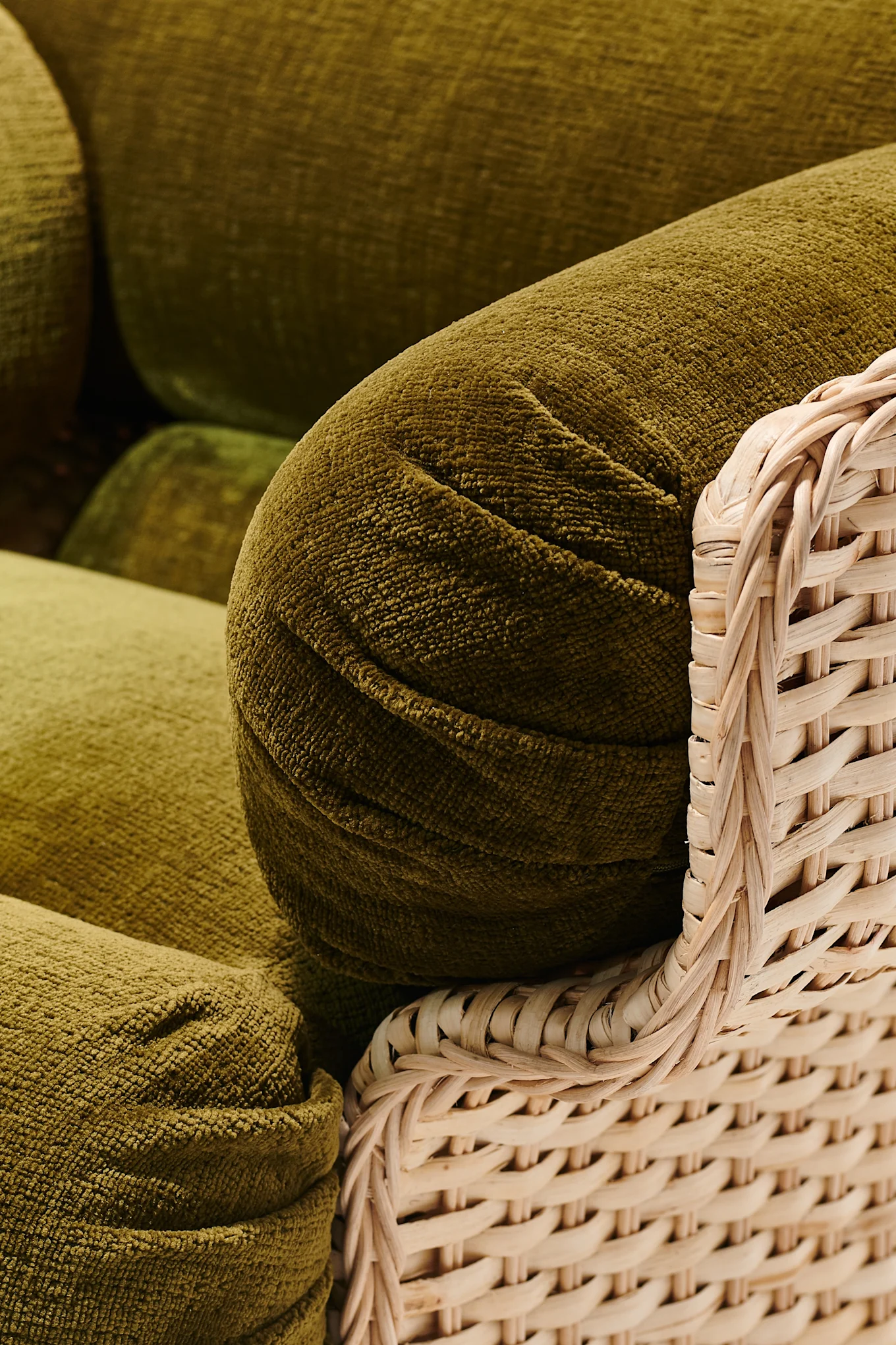 Oliivinvihreä nojatuoli, jossa on boheemi tunnelma ja joka heijastaa vuoden 2026 sisustustrendejä.
