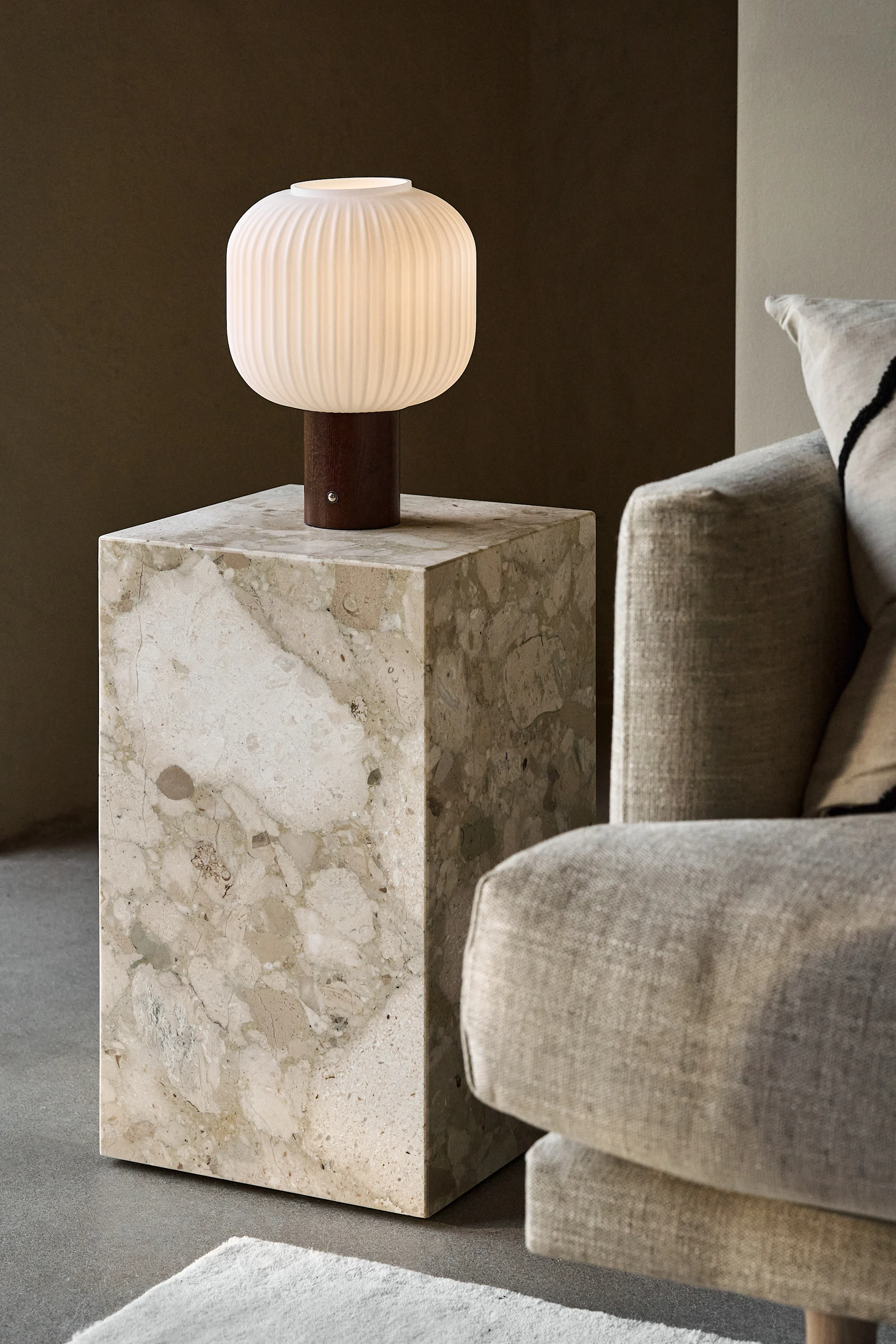 Beigenvärisen sohvan vieressä on marmorinen Plinth-sivupöytä, jolla on Scandi Livingin kannettava Fair-pöytävalaisin.